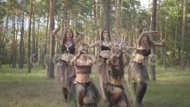 穿着森林居民或魔鬼的戏剧服装在森林里<strong>跳舞</strong>表演或做仪式的年轻妇女